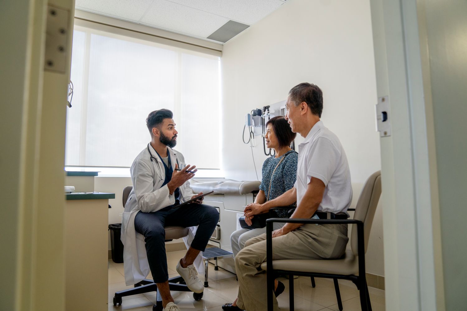 Physician speaks to man and woman